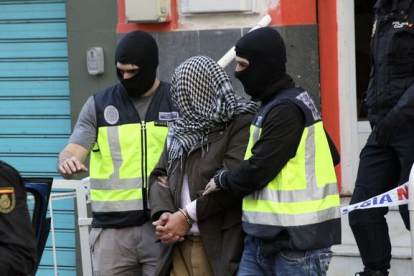 La policía traslada a uno de los detenidos en Ceuta por su presunta relación con las organizaciones terroristas Estado Islámico y Jabhat al Nusra.
