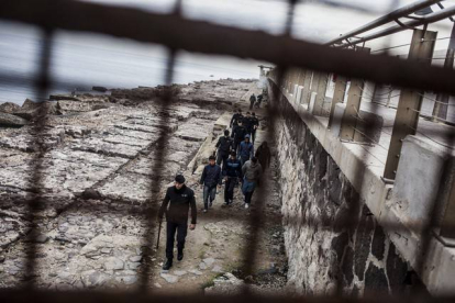 Agentes españoles caminan junto a un grupo de jóvenes marroquís que han entrado de forma ilegal en Melilla, el pasado día 13.