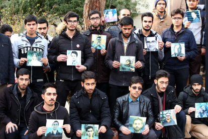 Protesta de estudiantes iraníes sosteniendo retratos de fallecidos en el derribo del avión.