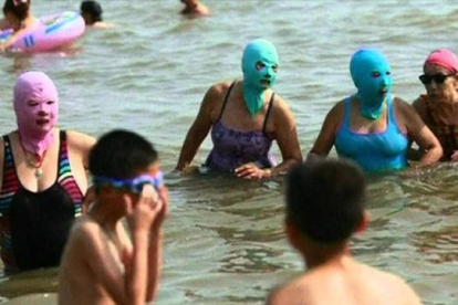 Mujeres con facekini en una playa de China.