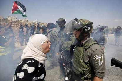 Una mujer palestina discute con un policía fronterizo israelí durante una protesta contra los asentamientos judíos en la aldea cisjordana de Nabi Saleh, cerca de Ramallah.