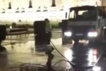 Un empleado de la limpieza, con la manguera y el camión para la limpieza a presión limpia ayer a las 23:49 de la noche los nombres escritos en San Marcos