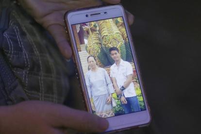 La tia de Ekapol Chanthawong muestra una foto en el móvil del entrenador en la que aparace junto a su abuela.