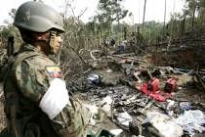 Miembros de la Fuerzas Militares ecuatorianas observan los cuerpos de varios guerrilleros