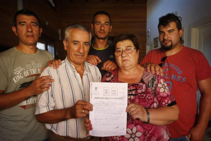 Carmen González y Cayetano Martínez con sus tres hijos muestran el certificado de defunción de su primogénito que piensan que les robaron en 1975. JESÚS F. SALVADORES
