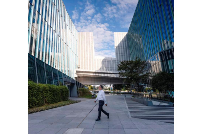 Un hombre camina frente al edificio de la sede de Sinic Holdings Shanghai, en impago. ALEX PLAVEVSKI
