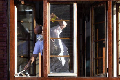 Un hombre arregla el alfeizar de una ventana en Valladolid este martes. NACHO GALLEGO