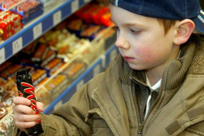 Un niño coge una barra de una galleta dulce de un supermercado en Reino Unido. SAM STEPHENSON