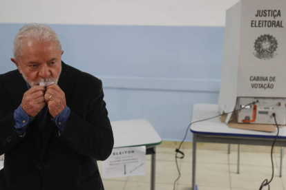 Lula besa la papeleta ayer, en el colegio donde votó. FERNANDO BIZERRA