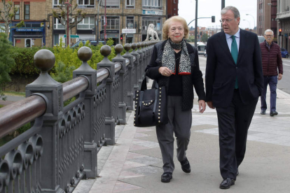 El candidato del PP, Antonio Silván, en el paseo diario con su madre, María Teresa Rodríguez, por el puente de los leones. RAMIRO