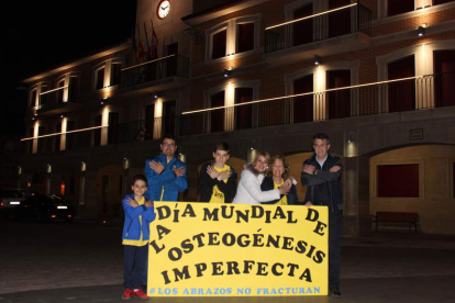Slavi y su familia, al alcalde y la edil de Bienestar Social, con el Ayuntamiento iluminado de amarillo. DL