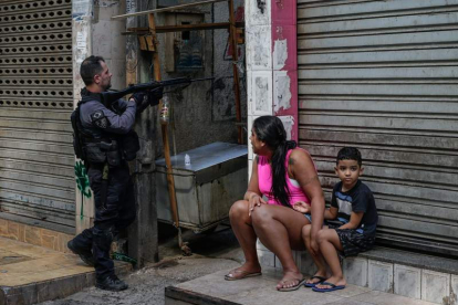 Una mujer y un niño contemplan la operación en la favela. ANDRÉ COELHO