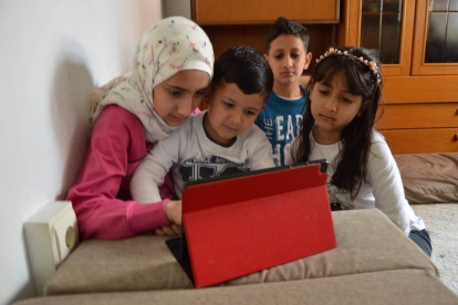 Niños y niñas de familias refugiadas consultan en un ordenador cedido por San Juan de Dios DL