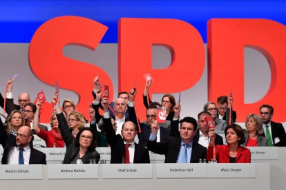 Miembros de la dirección del SPD votan, junto a los demás delegados, a favor de negociar con Merkel.