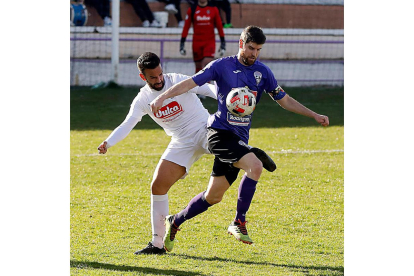 Álvaro se lleva un balón a pesar de la oposición de un rival. MARCIANO