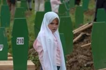 Una niña observa las tumbas de más de seiscientos musulmanes bosnios en los funerales de ayer