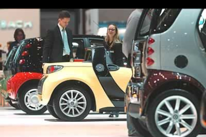 Unos periodistas examinan unos coches Smart expuestos en batería. Destacan por su colorido y por su original diseño.