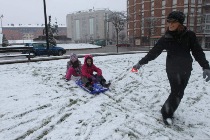 Dos niños juegan junto a su madre en uno de los parques del centro de Ponferrada.