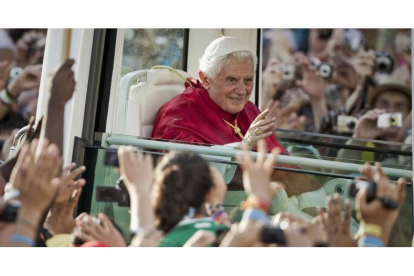 Benedicto XVI saluda desde el papamóvil a los jóvenes en la plaza de Cibeles.