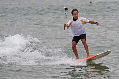 La antorcha olímpica surfea en las playas de Río.