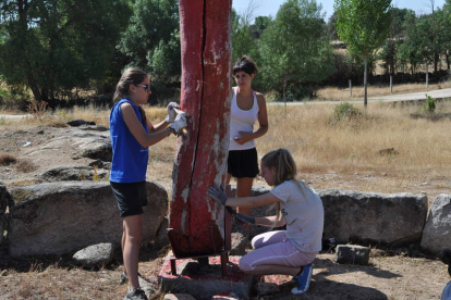 Tres jóvenes trabajan en el campo de trabajo de Monleras.