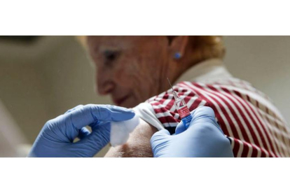 Una mujer recibe una vacuna contra la gripe. MANUEL BRUQUE