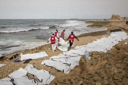 Decenas de cuerpos sin vida de inmigrantes alineados en una playa de Zawiya, ayer.