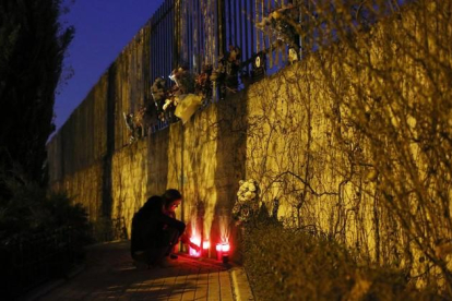 Una mujer enciende velas fuera de la estación de Atocha de Madrid en el undécimo aniversario del atentado del 11-M