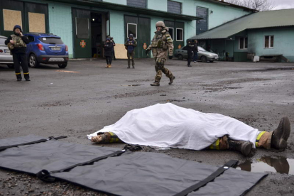 Un soldado pasa junto a un cuerpo tras el bombardeo de una estación de bomberos en Kherson. IVAN ANTYPENKO