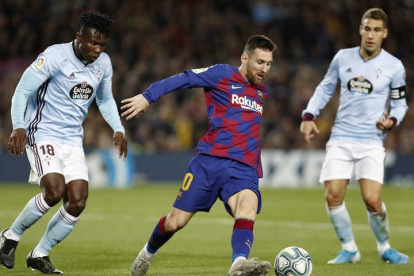 El delantero argentino del FC Barcelona, Leo Messi (c), controla el balón ante el defensa ghanés del Celta de Vigo, Joseph Aidoo, durante el encuentro correspondiente a la jornada trece de primera división que disputan esta noche en el estadio del Camp Nou, en Barcelona. EFE/Andreu Dalmau