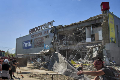 Voluntarios limpian los escombros de un centro comercial destruido por una bomba. SERGEY KOZLOV