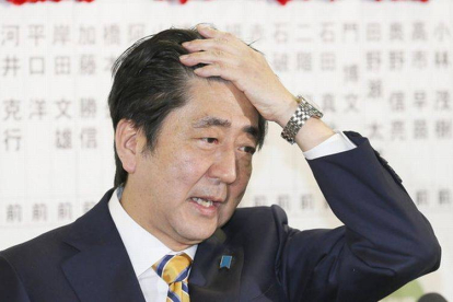 El primer ministro japonés, Shinzo Abe, hace un gesto de alivio tras conocer los sondeos que apuntan a su victoria en los comicios de este domingo.