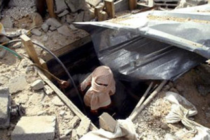 Un palestino sale de un túnel tras un ataque aéreo israelí.