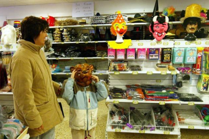 Una madre y un niño miran disfraces en una tienda.