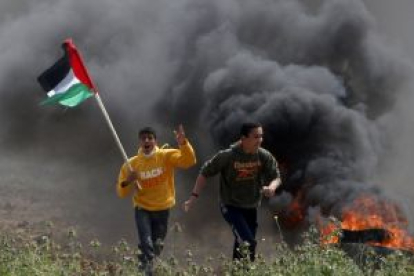 Dos jóvenes palestinos huyen de los soldados israelís cerca de la ciudad de Gaza, ayer.