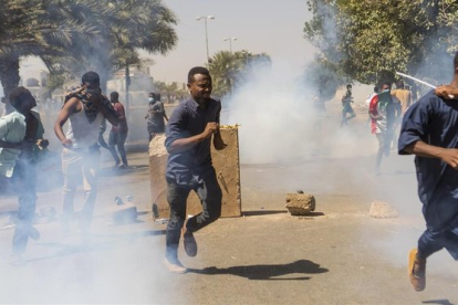 Manifestantes se protegen de los gases lacrimógenos de las fuerzas de seguridad en Jartum.