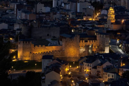 El Castillo de los Templarios y la torre de la Basílica de la Encina, dentro del casco histórico de Ponferrada, iluminados por la noche.