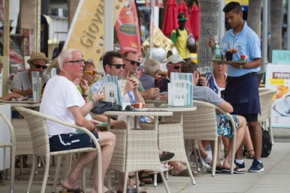 Un camarero atiende a unos turistas en una terraza de Palma de Mallorca.
