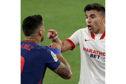 Luis Suárez y Acuña, autor del gol del Sevilla, discuten tras una acción del partido. JULIO MUÑOZ