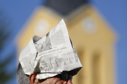 Un hombre se protege del sol con un gorro hecho de papel.