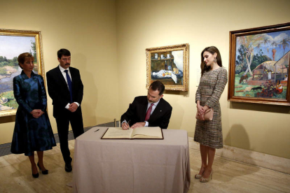 El rey firma en el libro de honor en presencia de su mujer y el presidente húngaro y su esposa. S. B.