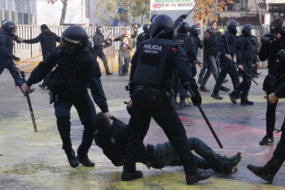 Dos mossos arrastran a un manifestante en la plaza del 1 dOctubre de Girona /