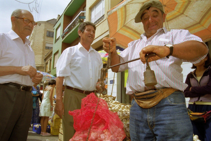 Un tendero pesa el producto en una balanza de contrapesos, en la feria del ajo del año 2.000. ANA M. DIEZ