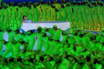 Un pianista acompañado de una niña, interpretan una melodía rodeados por un centenar de bailarines.