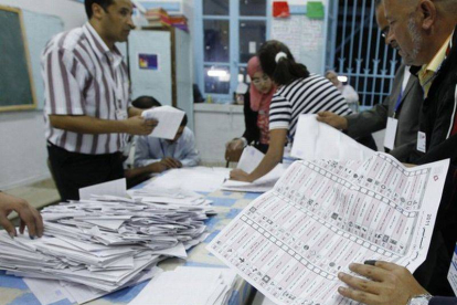 Varias personas realizan el recuento de votos en un colegio electoral, en Túnez, ayer.