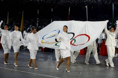 Ocho deportistas, cuatro mujeres y cuatro hombres, han portado la bandera olímpica con un uniforme diseñado por una estudiante de 18 años.