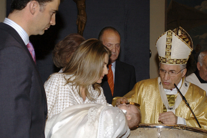 La princesa Leonor, en brazos de su madre, la reina Letizia, junto al rey Felipe y los reyes eméritos Juan Carlos y Sofía, el 14 de enero de 2006, durante su bautizo oficiado por el arzobispo de Madrid, el cardenal Antonio María Rouco Varela (d), en el vestíbulo del Palacio de la Zarzuela. EFE/BALLESTEROS