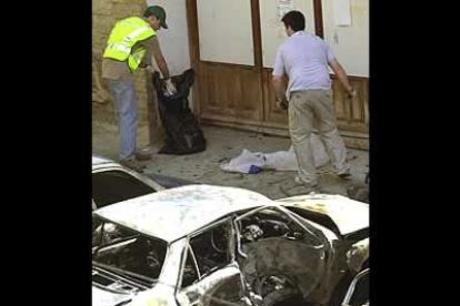 Dos operarios retiran los restos de los compañeros asesinados por la banda terrorista ETA en la localidad navarra de Sangüesa.