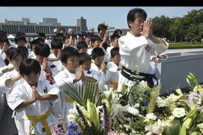 Un grupo de estudiantes japoneses de kárate también reza ante el cenotafio.