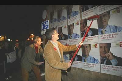 Francisco Fernández, cadidato socialista en León, pegando una de sus imágenes.